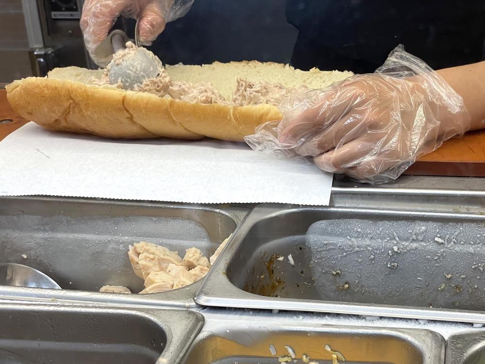 A worker at a Subway sandwich shop makes a tuna sandwich last year in San Anselmo, California. A lawsuit in federal court accuses the restaurant giant of not using 100% tuna in its offerings — and a judge has denied Subway's request to dismiss the suit.