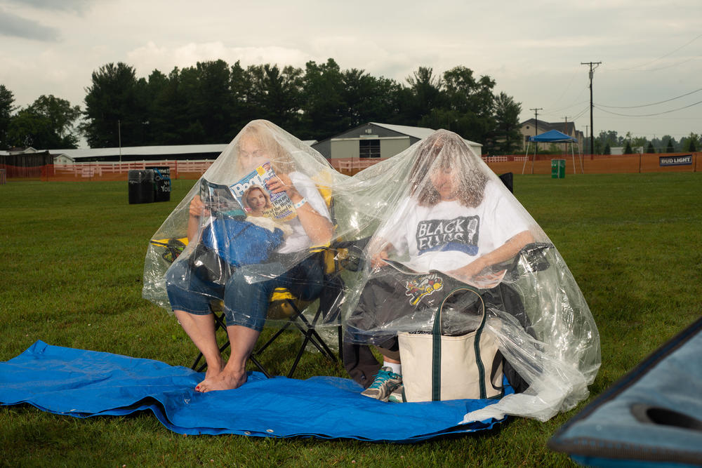 Two women wait out the rain at the Michigan Elvisfest on Friday, July 8.