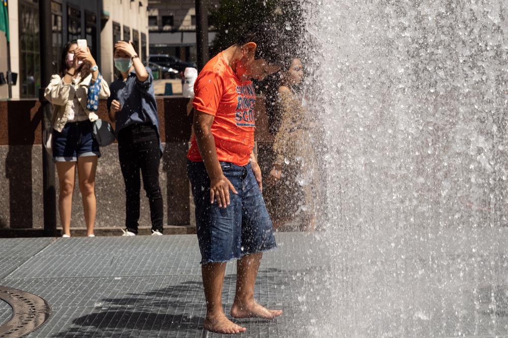 People play in artist Jeppe Hein's water-based sculpture titled <em>Changing Spaces</em> at Rockefeller Center Plaza in New York City on Tuesday.