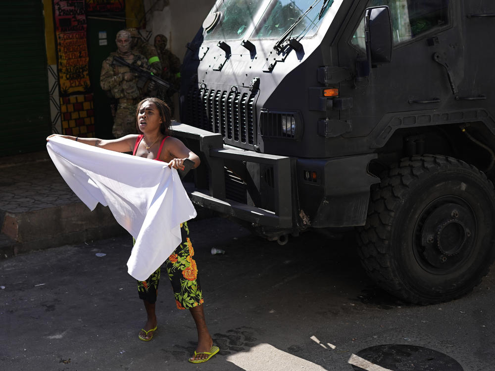 A resident waves a white sheet in protest and to ask for peace after a police operation that resulted in multiple deaths, in the Complexo do Alemao favela in Rio de Janeiro on Thursday.
