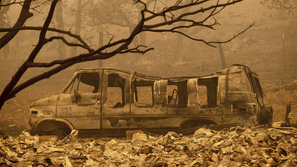 A scorched van sits in a clearing as the McKinney Fire burns in Klamath National Forest, Calif., on Sunday.