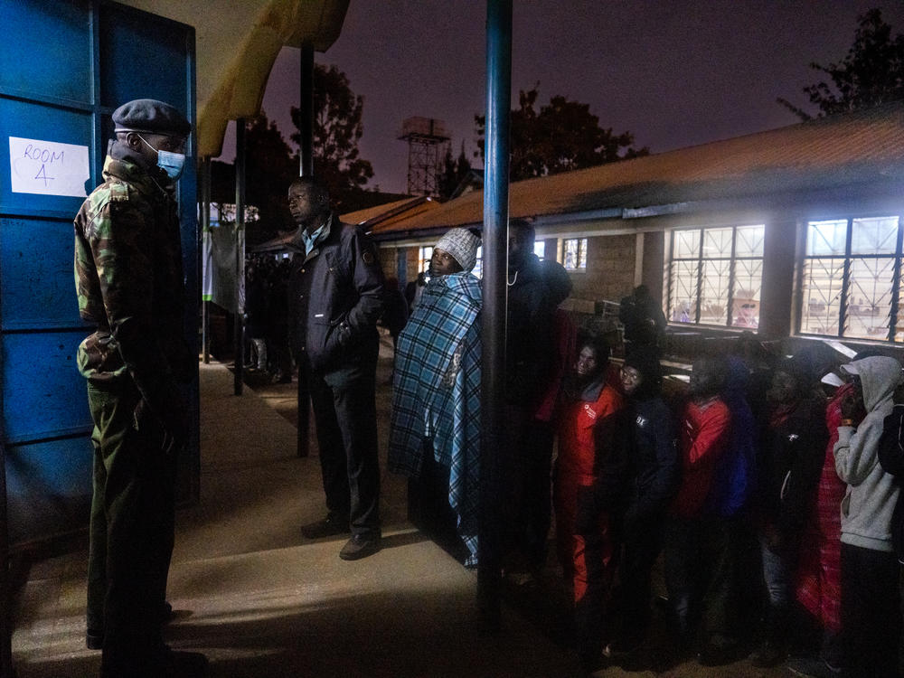 The first voters in the Kibera slum in Nairobi, Kenya, look into one of the many polling rooms at Olympic Primary just minutes before voting commences on Tuesday.