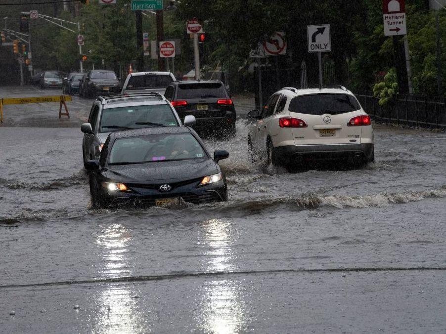 Cars drive on flooded streets as Tropical Storm Henri approaches, in Hoboken New Jersey on August 22, 2021.