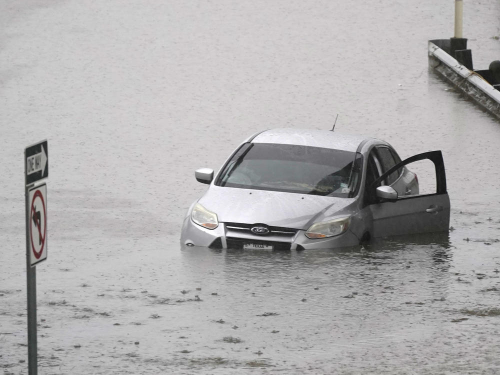 A car sits in flood waters covering a closed highway in Dallas on Monday.