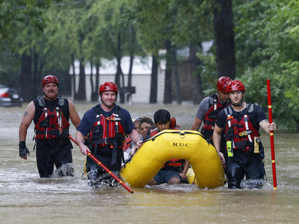 Members of the Balch Springs Fire Department bring a family of four by boat to higher ground after rescuing them from their home along Forest Glen Lane in Balch Springs, Texas, on Monday.