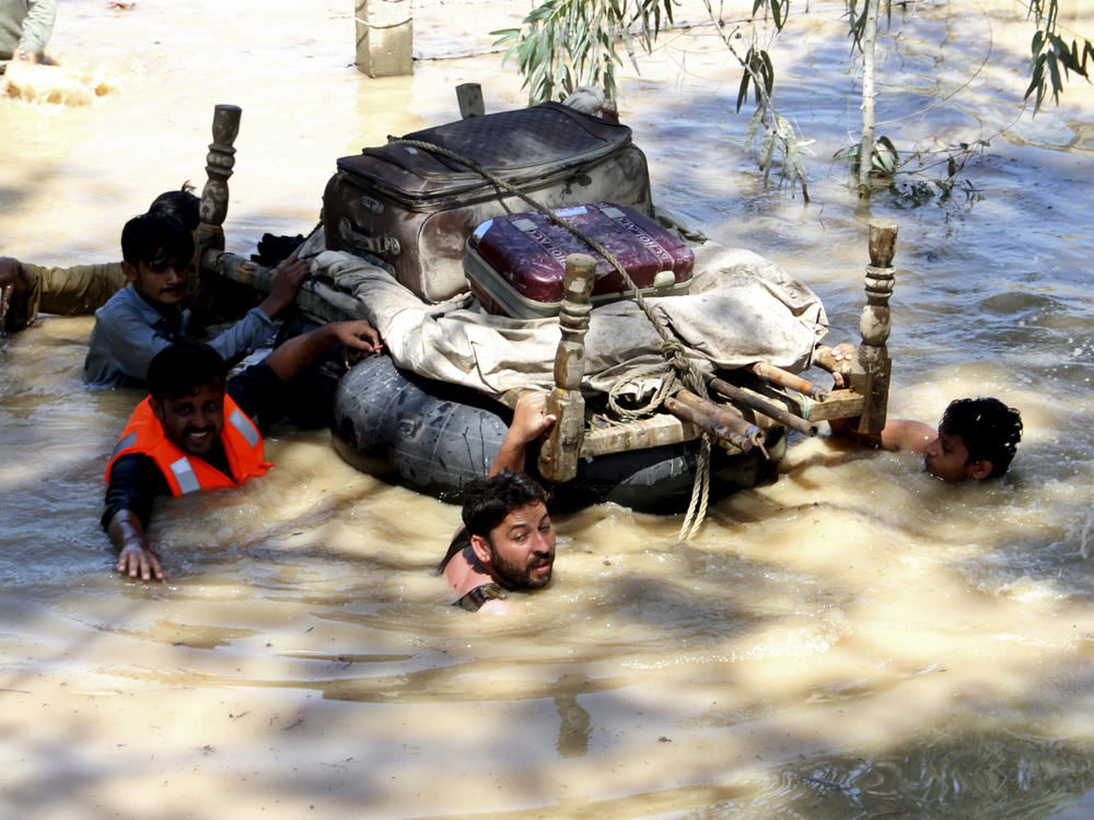 Displaced people float belongings salvaged from flood-hit homes on the outskirts of Peshawar, Pakistan, on Sunday.