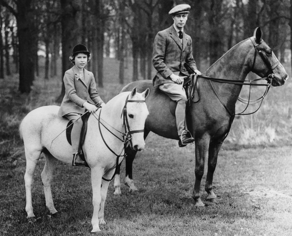 <strong>Circa 1930s:</strong> King George VI rides horses with his daughter Princess Elizabeth.