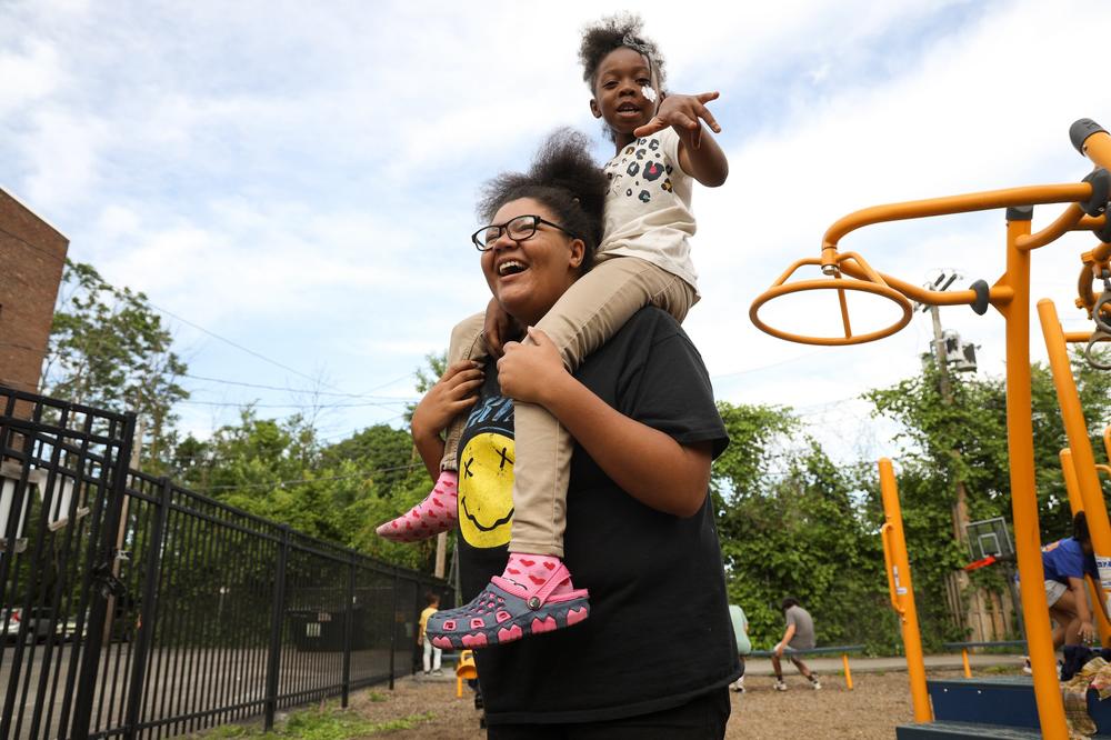 Kaila Toppin carries after-school student Blessyn Mays on the playground at Cameron Community Ministries.