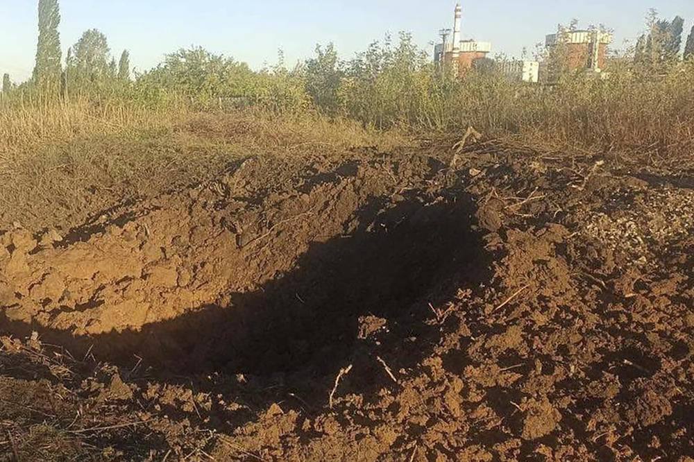 A crater left by a Russian rocket is seen 300 meters from the South Ukraine nuclear power plant, in the background, close to Yuzhnoukrainsk, Mykolayiv region, Ukraine, on Monday.