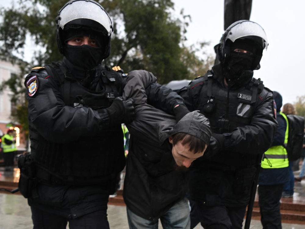 Police officers detain a man in Moscow on Saturday following calls to protest against the military draft announcement.