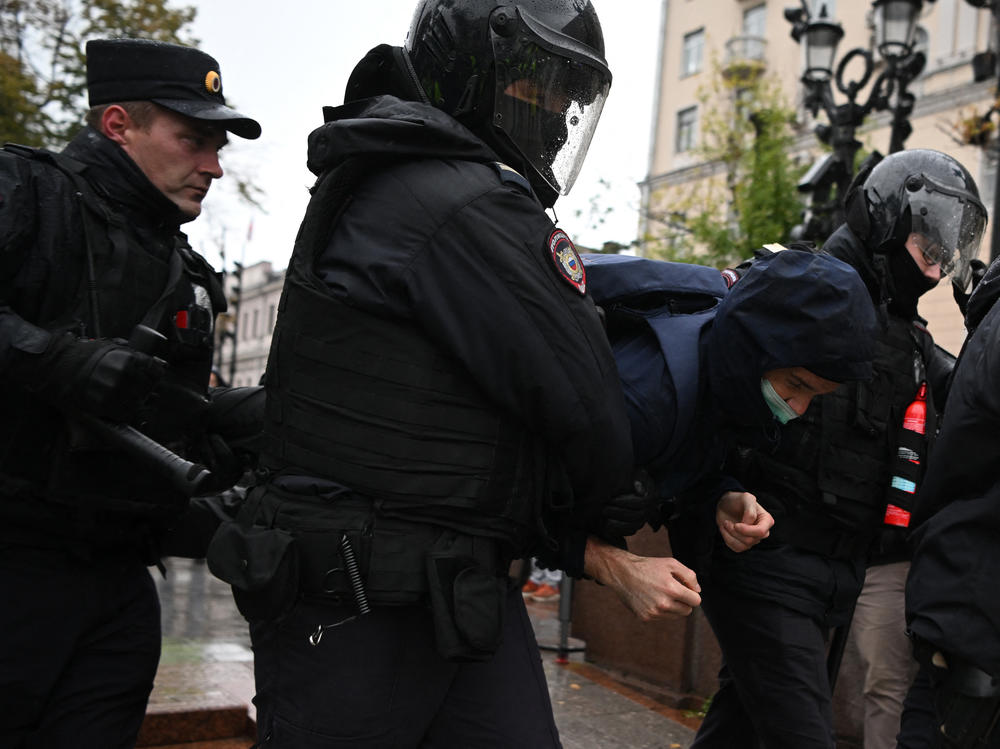 Police officers detain a man in Moscow on Saturday.