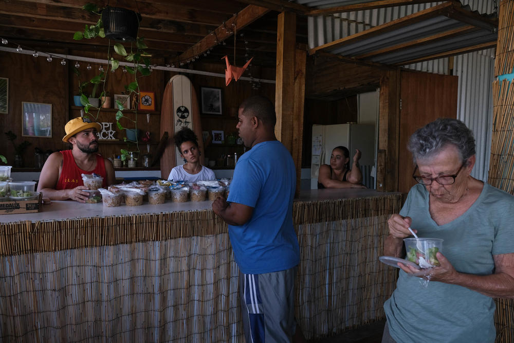 Residents of the Pozuelo community in Guayama, Puerto Rico, pick up meals at the Tropishack.