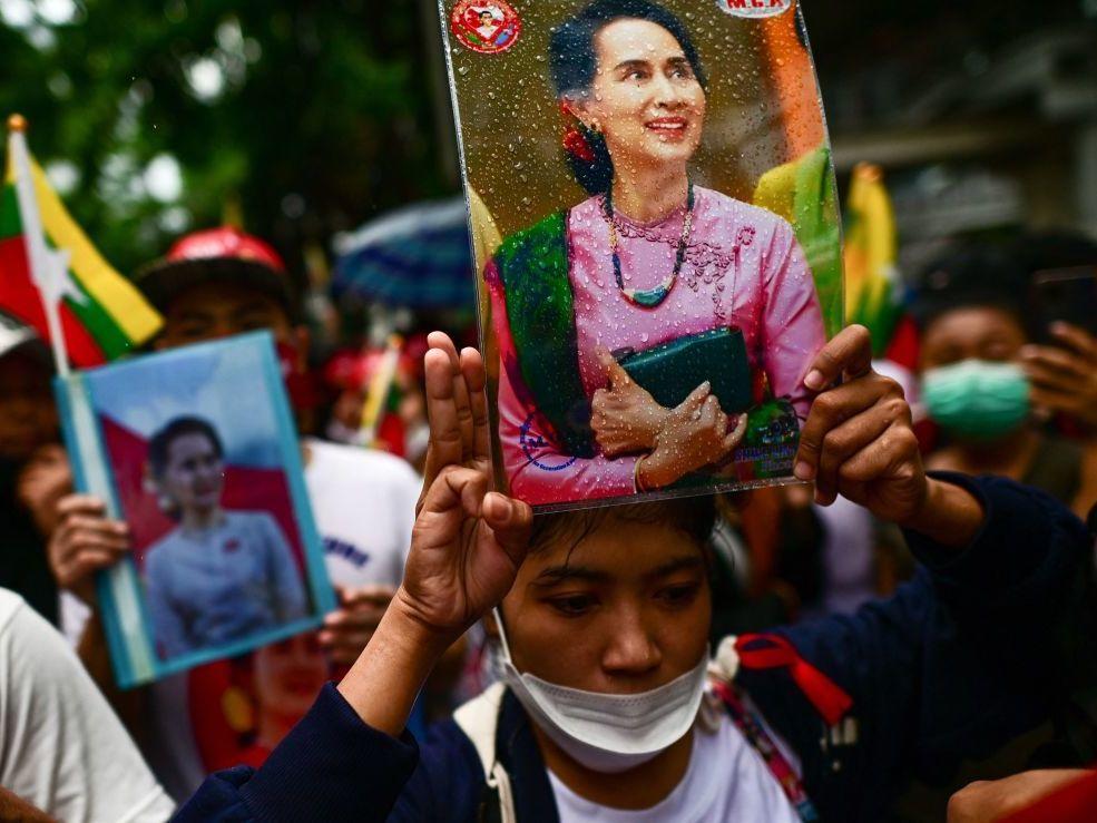 Protesters show the three finger salute and hold photos of detained Myanmar civilian leader Aung San Suu Kyi in July outside the Myanmar Embassy in Bangkok during a demonstration against the Myanmar military junta's execution of four prisoners.