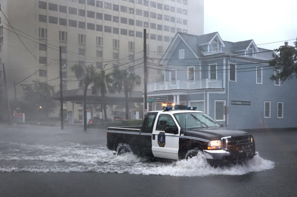 A police vehicle moves down a flooded street as rain from Hurricane Ian drenches Charleston on Sept. 30.