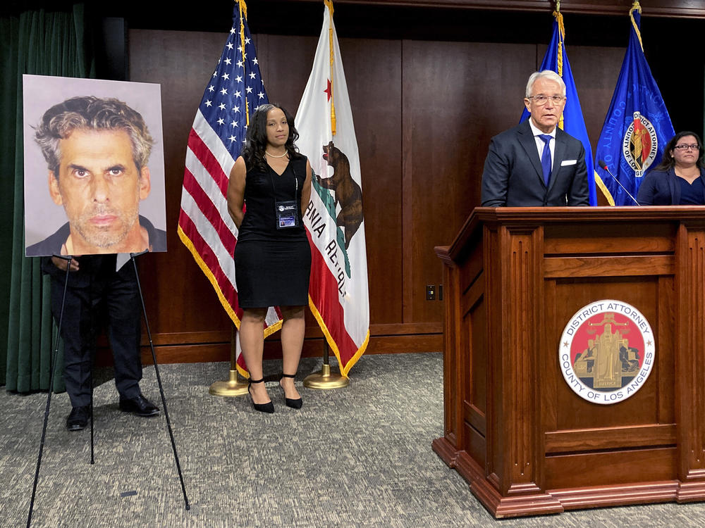 Los Angeles District Attorney George Gascon stands by a photo of TV producer Eric Weinberg during a news conference to announce sexual assault charges against Weinberg on Wednesday in Los Angeles.