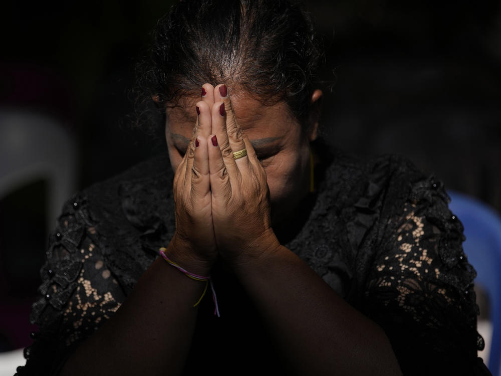 The relative of a victim in a mass killing attack prays for a Buddhist ceremony inside Wat Rat Samakee temple in Uthai Sawan, north eastern Thailand, Tuesday, Oct. 11, 2022.