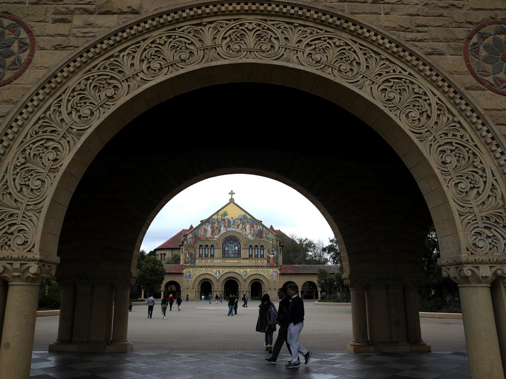 Students and visitors walk on Stanford University's campus in 2019.