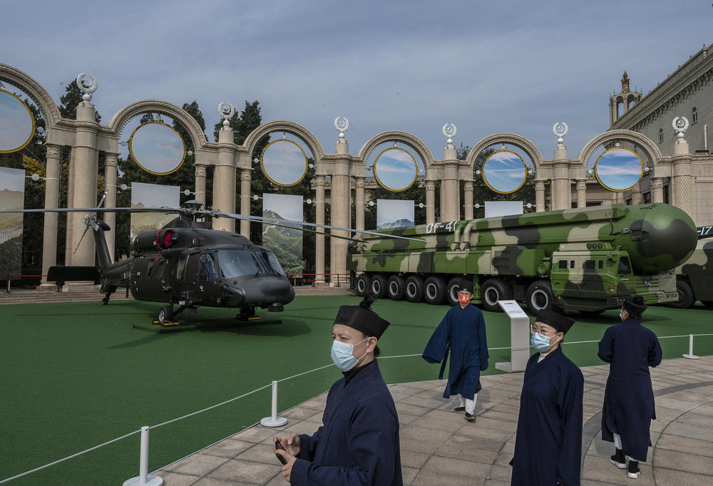 Party members look at a helicopter and missile launcher as part of a display of military hardware at an exhibition highlighting President Xi Jinping's years as leader, as part of the upcoming 20th Party Congress, in Beijing on Wednesday.