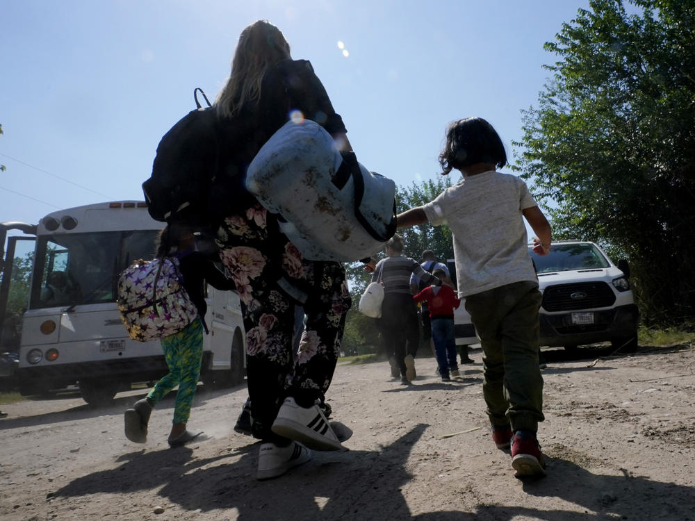 A migrant family from Venezuela walks to a Border Patrol transport vehicle after they and other migrants crossed the U.S.-Mexico border and turned themselves in June 16, 2021, in Del Rio, Texas.