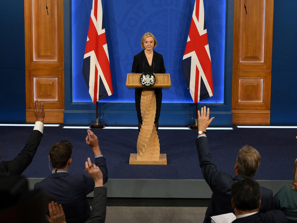 Journalists raise their hands for questions as Britain's Prime Minister Liz Truss holds a news conference in the Downing Street Briefing Room in central London, Friday. Truss let go her finance chief Kwasi Kwarteng and reversed course on sweeping tax cuts.