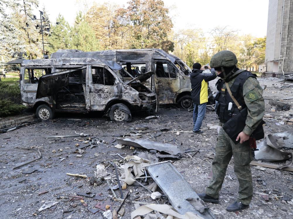Investigators inspect a site after shelling near an administrative building in Donetsk on Sunday.