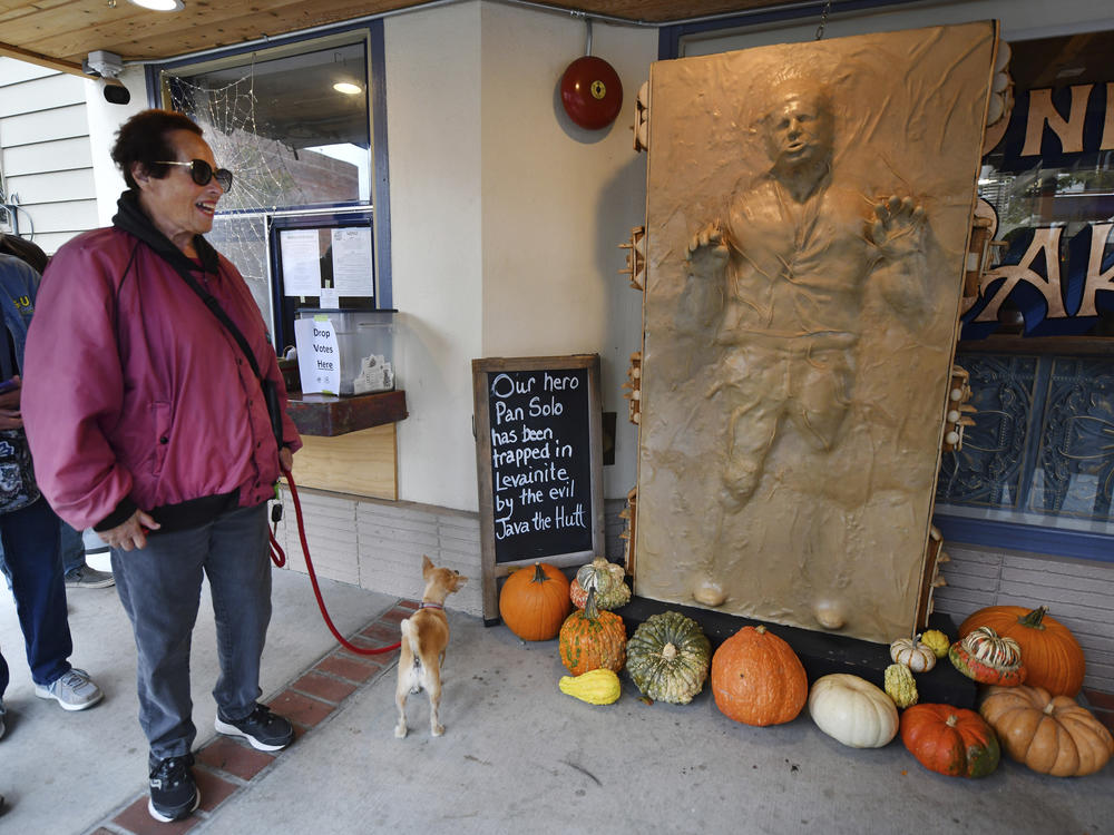 A customer and her dog enjoy a sculpture of 