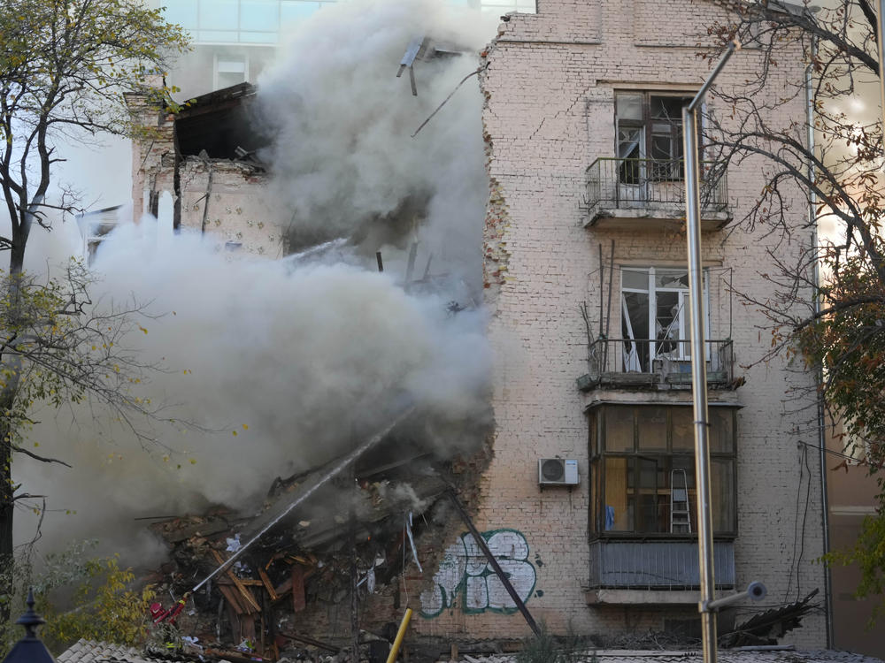 Firefighters work after a drone fired on buildings in Kyiv on Monday.
