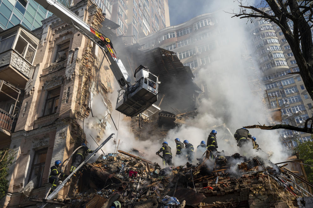 Firefighters work in the rubble of a building in Kyiv on Monday.