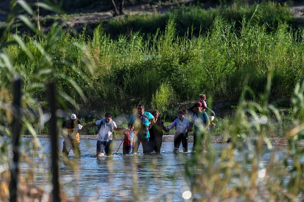 A migrant family from Venezuela illegally crosses the Rio Grande in Eagle Pass, Texas, at the border with Mexico on June 30.