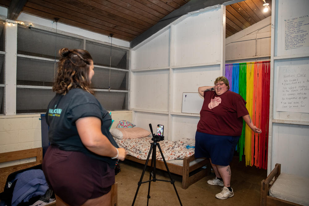 Molly Brubaker watches Jill Baugess record a TikTok of herself dancing in a Camp Roundup T-shirt after dinner on the first night of camp.