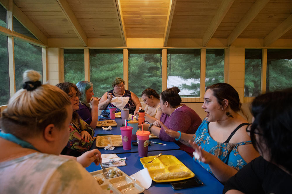 Campers chat over dinner in the main cabin at Camp Roundup, a body positivity and acceptance camp for women that took place Labor Day weekend in Newark, Ohio.