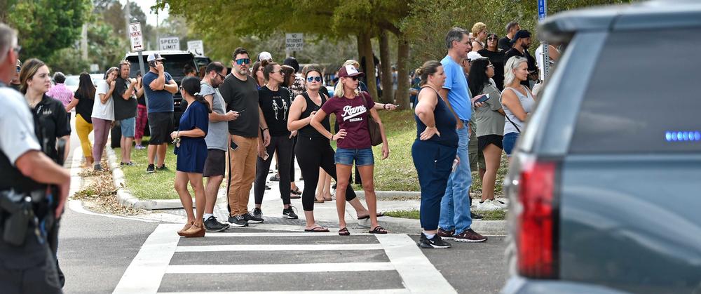 Families wait to be reunited with their children following the report of an active shooter that turned out to be a hoax at Riverview High School in Sarasota, Fla., on Oct. 11. Sarasota law enforcement, state troopers, ambulances and fire trucks all responded to the false threat.
