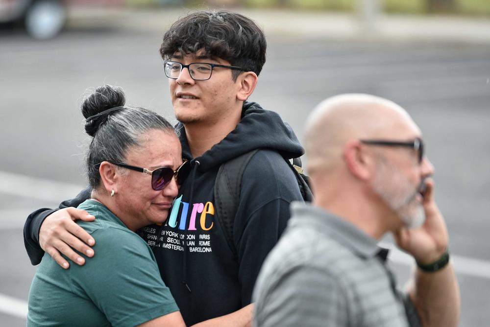 High school junior Eldrige Coronel, 17, hugs his mom, Veronica Padilla, after a report of an active shooter that turned out to be a hoax at Riverview High School in Sarasota, Fla. Oct. 11. Distraught parents waited for their children at the perimeter of the school as Sarasota law enforcement, state troopers, ambulances and fire trucks all responded to the false threat.