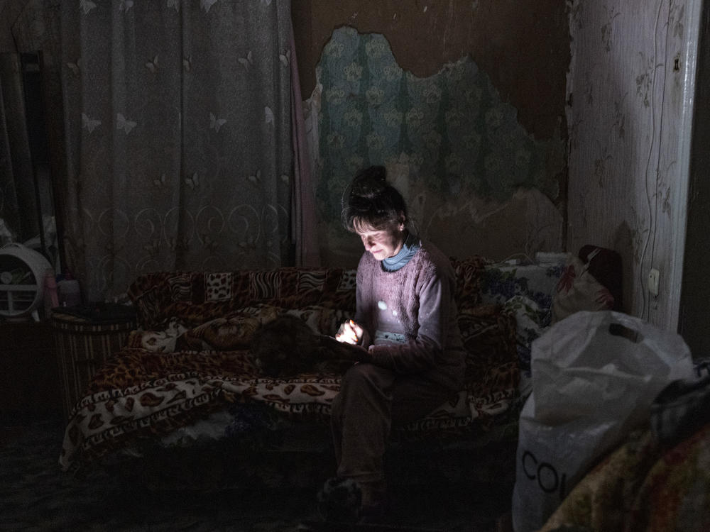Tetyana Safonova looks at her mobile phone during a power outage on Thursday in Borodyanka, Ukraine.