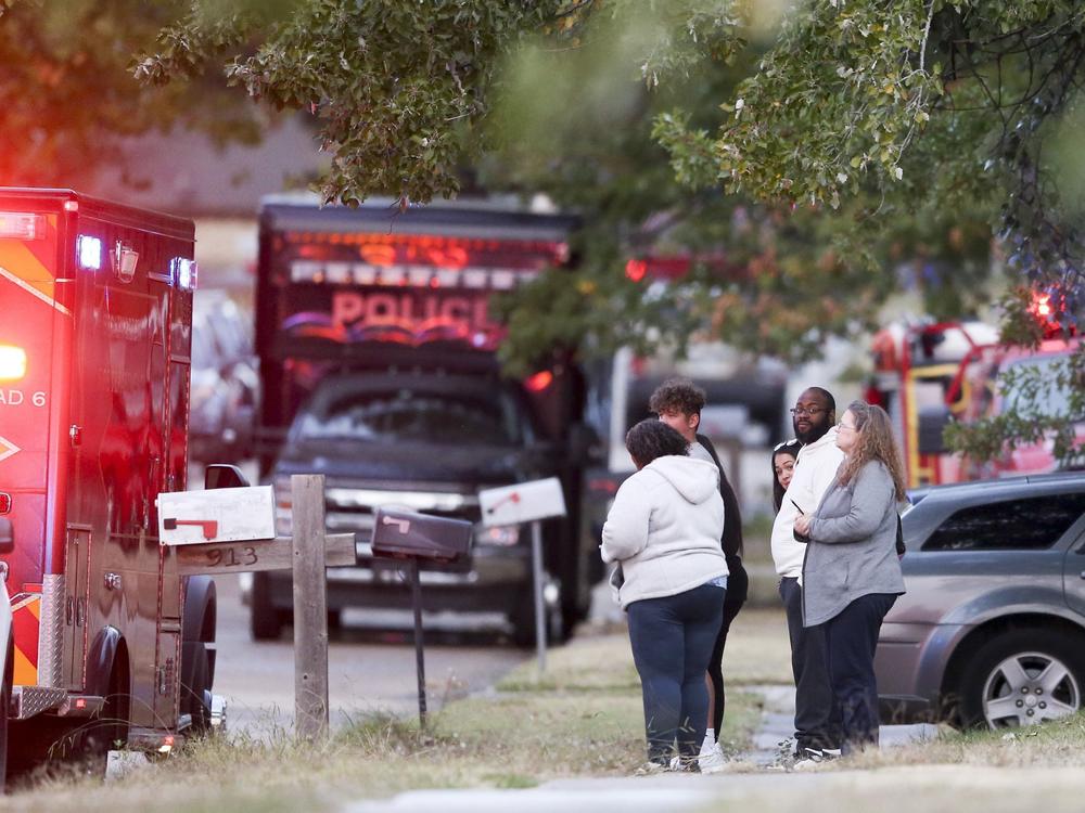 People look on as Broken Arrow, Okla., police and fire department investigate the scene of a fire with multiple fatalities at the corner South Hickory Ave. and West Galveston St. on Thursday, Oct. 27, 2022.
