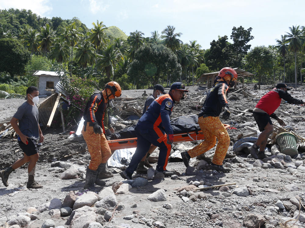 Rescuers carry a body at Maguindanao's Datu Odin Sinsuat town, southern Philippines on Sunday.