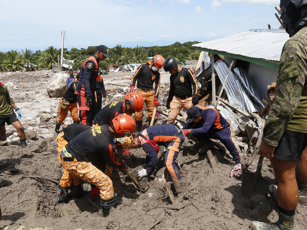 Rescuers work to retrieve a body at Maguindanao's Datu Odin Sinsuat town, southern Philippines on Sunday. Victims of a huge mudslide set off by Tropical Storm Nalgae in a coastal Philippine village that had once been devastated by a killer tsunami mistakenly thought a tidal wave was coming and ran to higher ground toward a mountain and were buried alive, an official said Sunday.
