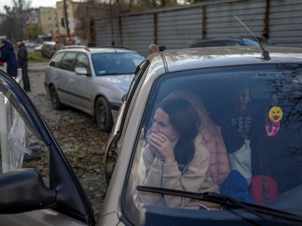 A Ukranian woman sits in a car with her family in Zaporizhzhia on Saturday, after they fled from the Russian-occupied territory of Kherson.