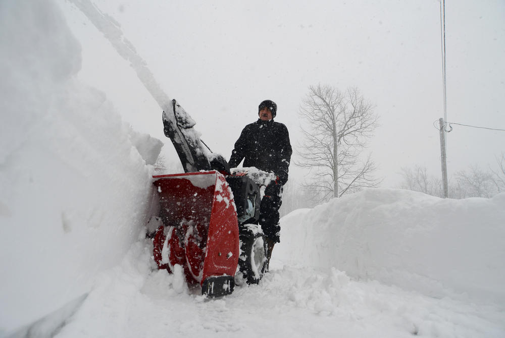 Denis Marszalkowski uses a snowblower to dig out after an intense lake-effect snowstorm hit Western New York.