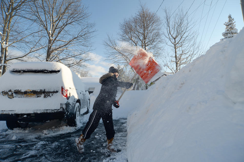 Heather Ahmed digs out after an intense lake-effect snowstorm impacted the Buffalo, New York, area on Saturday.