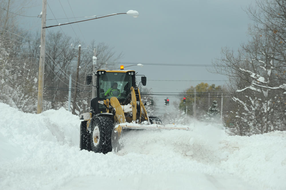 A National Guard loader clears a road after an intense lake-effect snowstorm impacted the area on Saturday in Hamburg, New York.