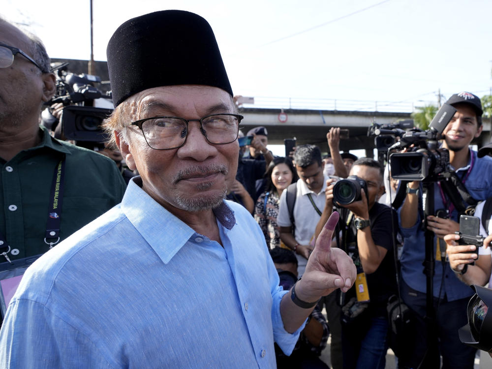 Opposition leader Anwar Ibrahim shows his inked finger to the media after voting at a polling station in Seberang Perai, Penang state, Malaysia on Nov. 19, 2022.