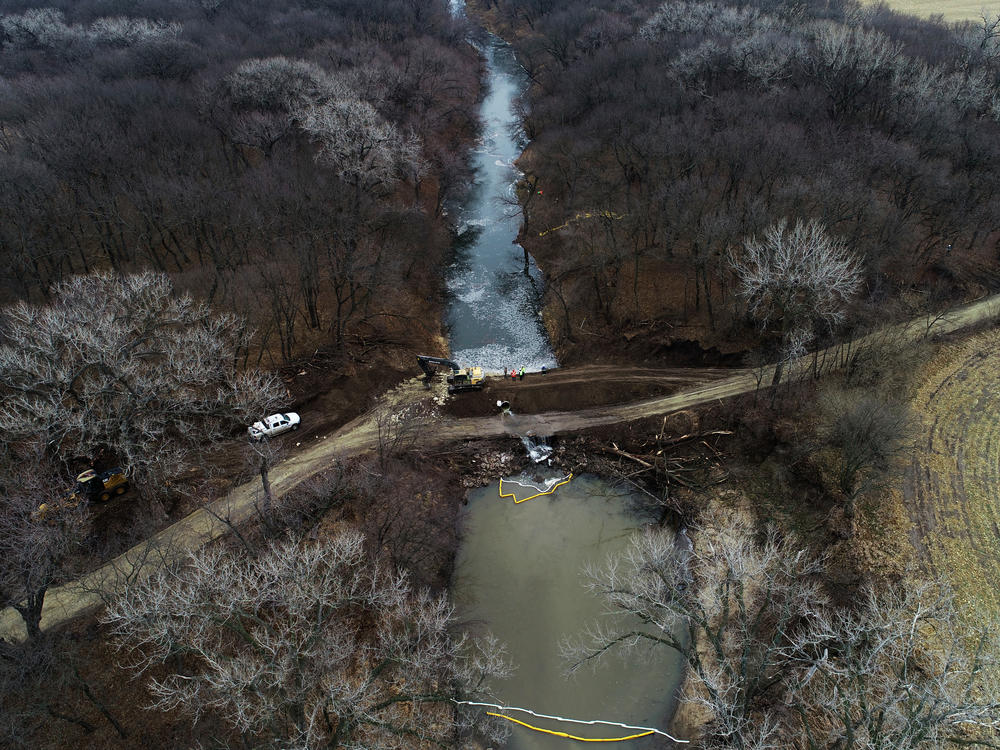 In this photo taken by a drone, cleanup continues in the area where the ruptured Keystone pipeline dumped oil into a creek in Washington County, Kan., on Friday.