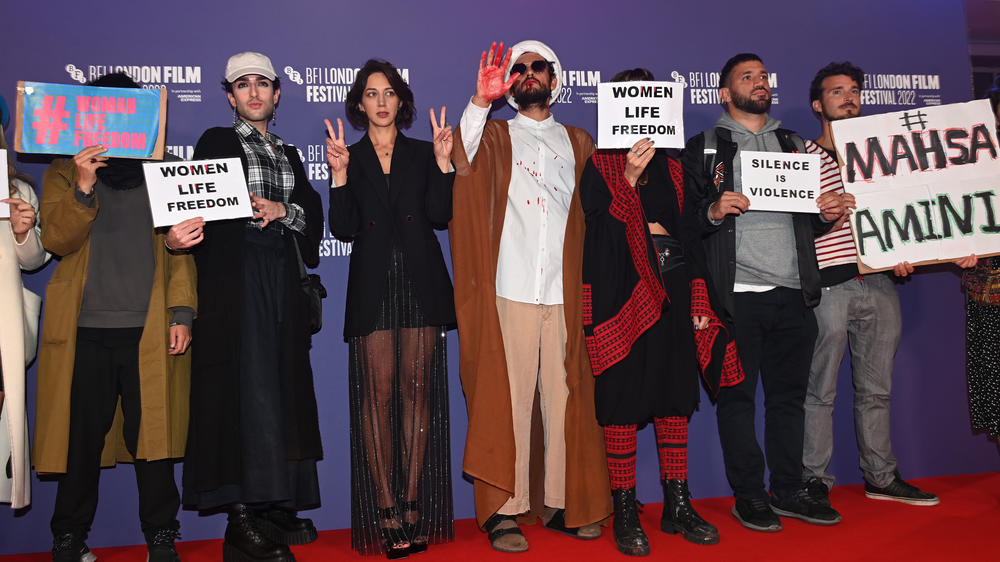 Alongside protesters, Ali Abbasi and Zar Amir Ebrahimi attend the <em>Holy Spider</em> UK premiere during the 66th BFI London Film Festival on Oct. 08, 2022 in London.