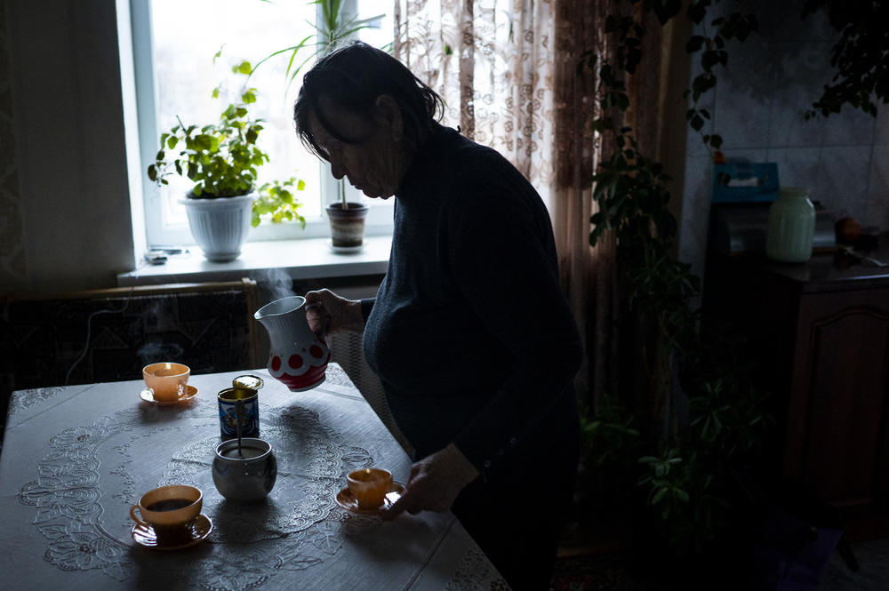 Raisa Yakymenko, 85, makes coffee in her apartment during a power outage in Bucha on Dec. 2.