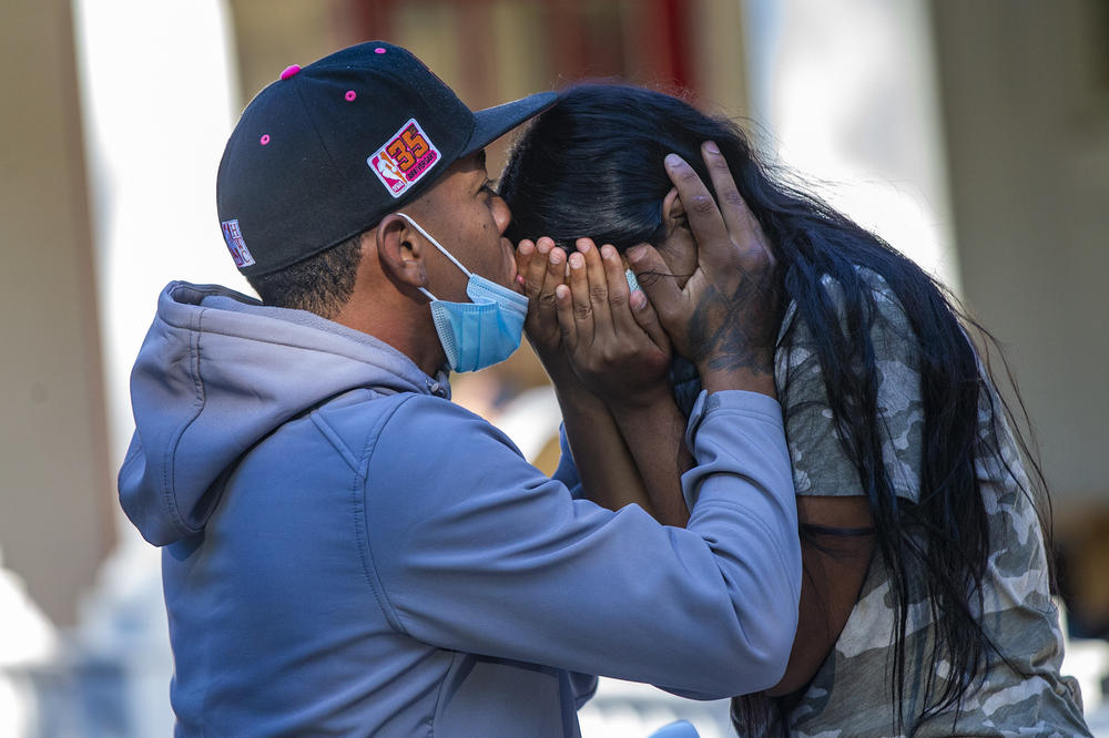 A young migrant couple embraces on the porch of St. Andrew's Parish House in Edgartown. Nearly 50 Venezuelans were flown to the island from Texas under what they said was a false pretense. Florida Gov. Ron DeSantis took credit for flying the immigrants to Massachusetts.