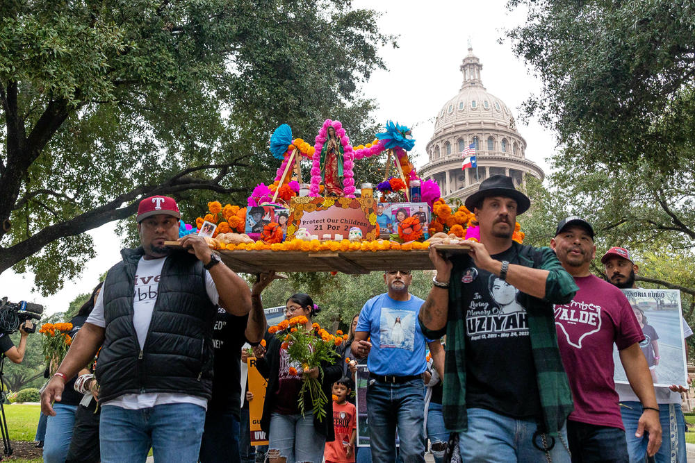 Día de Muertos altar for the 21 victims from the Robb Elementary School shooting being carried by the victims fathers from the Capitol to the Governor's Mansion, protesting for an age increase to purchase AR-15 and requesting everyone to vote. Full story <a href=