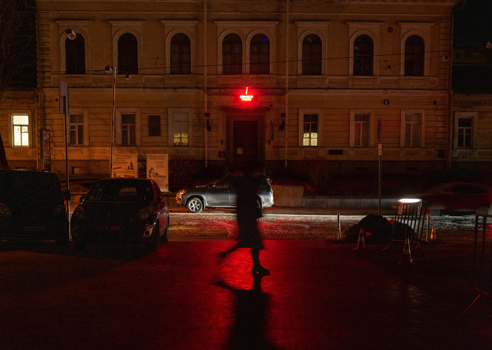 A woman walks through darkened Kyiv as many street lights remain off due to power shortages in the capital after numerous Russian air strikes on the country's energy infrastructure on Friday in Kyiv, Ukraine.