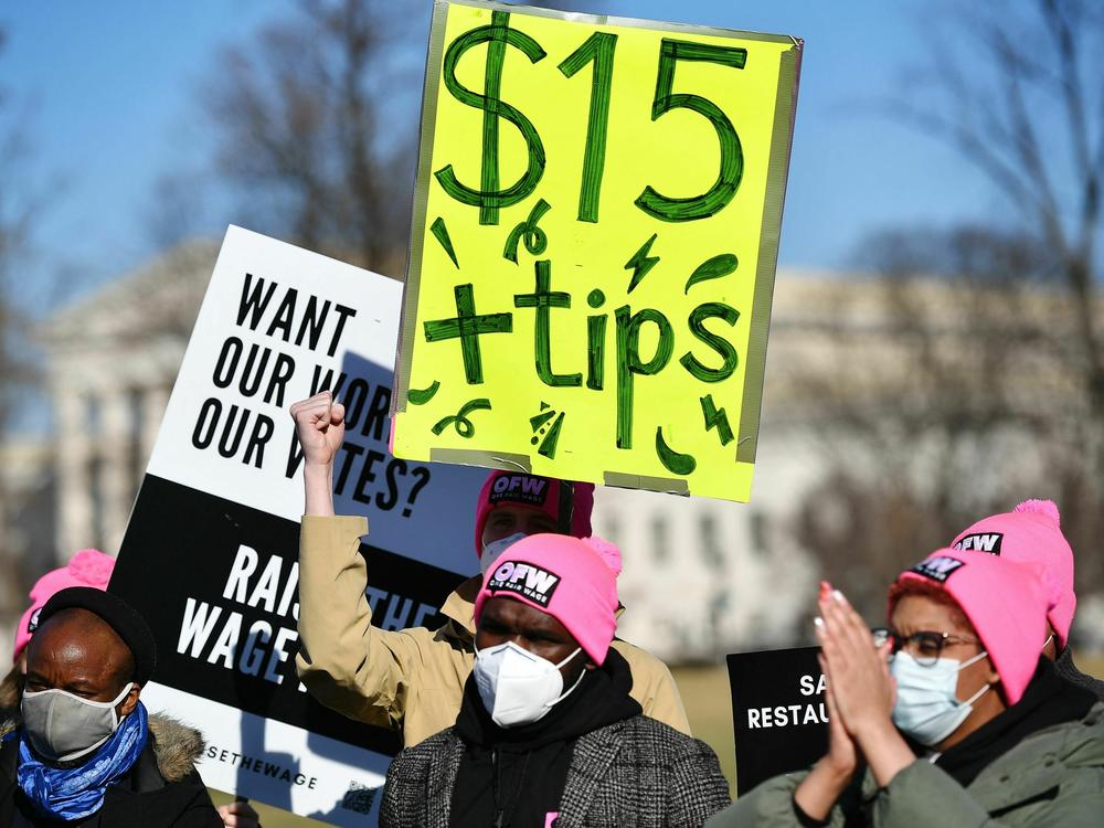 An activist holds a placard demanding a $15/hour minimum wage and tips for restaurant workers at the House Triangle of the U.S. Capitol in February.