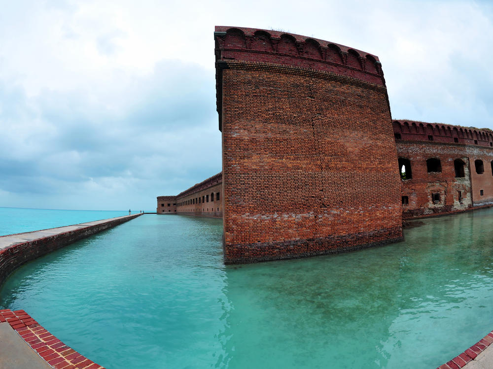 Over the holiday weekend, hundreds of migrants landed in Dry Tortugas National Park, about 70 miles west of Key West, Fla., in the Gulf of Mexico. Tourists walk along the sea wall surrounding Fort Jefferson in the park in February 2016.